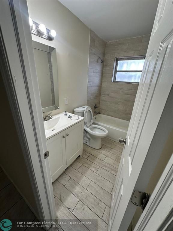 1350 East Sample Road, Unit 101 Pompano Beach, FL 33064 - Photo 8 of 8 a bathroom with a sink a toilet a mirror and shower