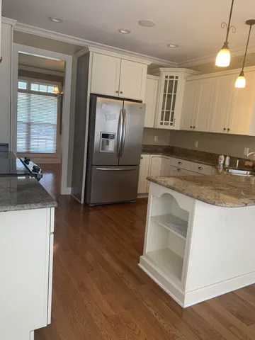 a kitchen with kitchen island granite countertop wooden cabinets and a sink