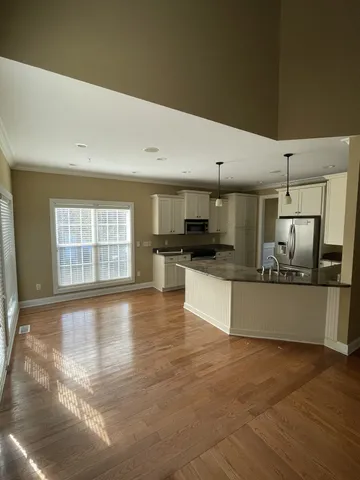 a large kitchen with stainless steel appliances a large counter top and a stove