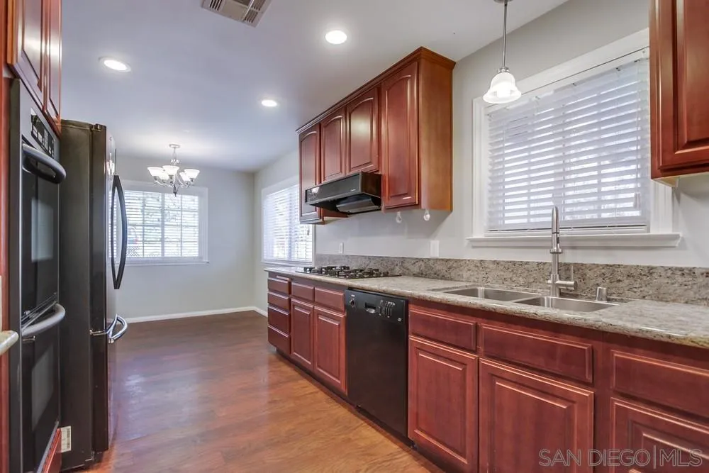 243 East View Street Fallbrook, CA 92028 - Photo 17 of 50 a kitchen with stainless steel appliances granite countertop wooden cabinets a sink and a window