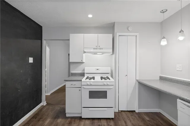 a white stove top oven sitting inside of a kitchen