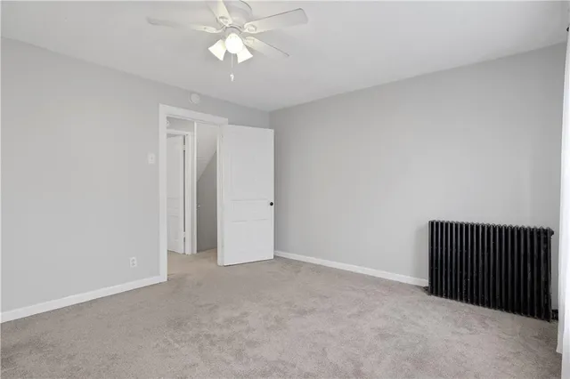 an empty room with a ceiling fan and a window