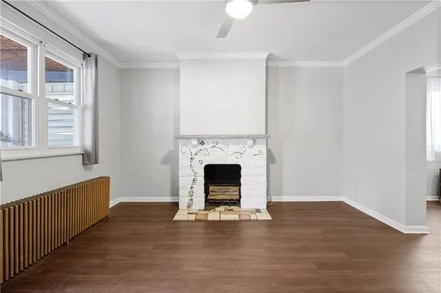 a living room with fireplace and wooden floor