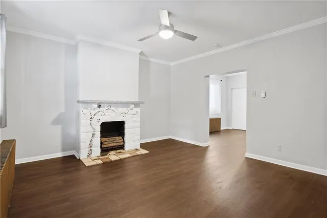 a view of a livingroom with wooden floor a fireplace and window
