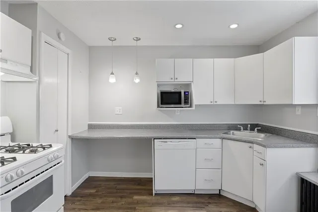 a kitchen with white cabinets and appliances