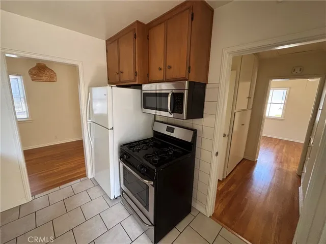 a kitchen with granite countertop a refrigerator and a stove top oven