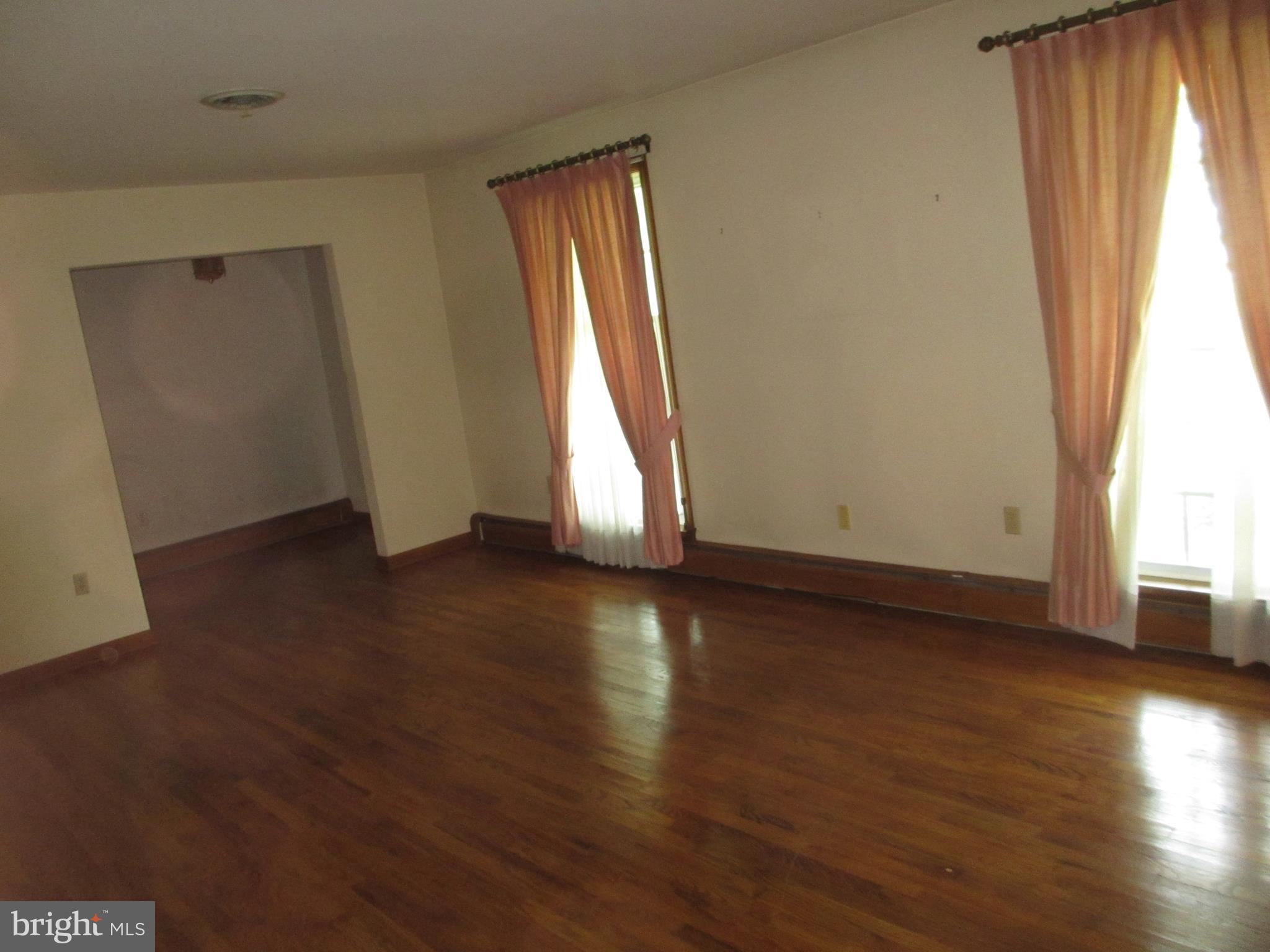 16 Nellies Corner Road Rising Sun, MD 21911 - Photo 16 of 25 an empty room with wooden floor and windows with curtains view