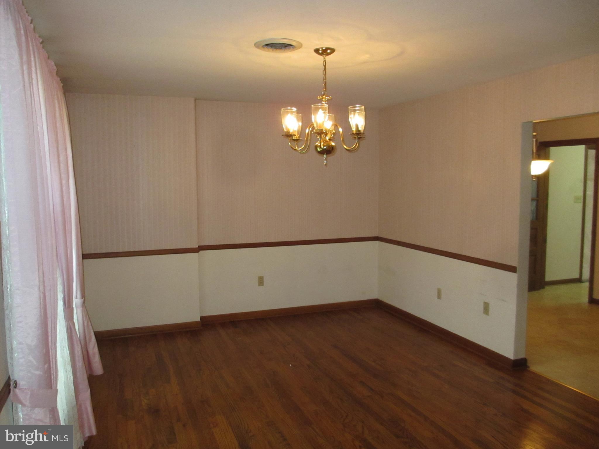 16 Nellies Corner Road Rising Sun, MD 21911 - Photo 18 of 25 an empty room with wooden floor chandelier and windows