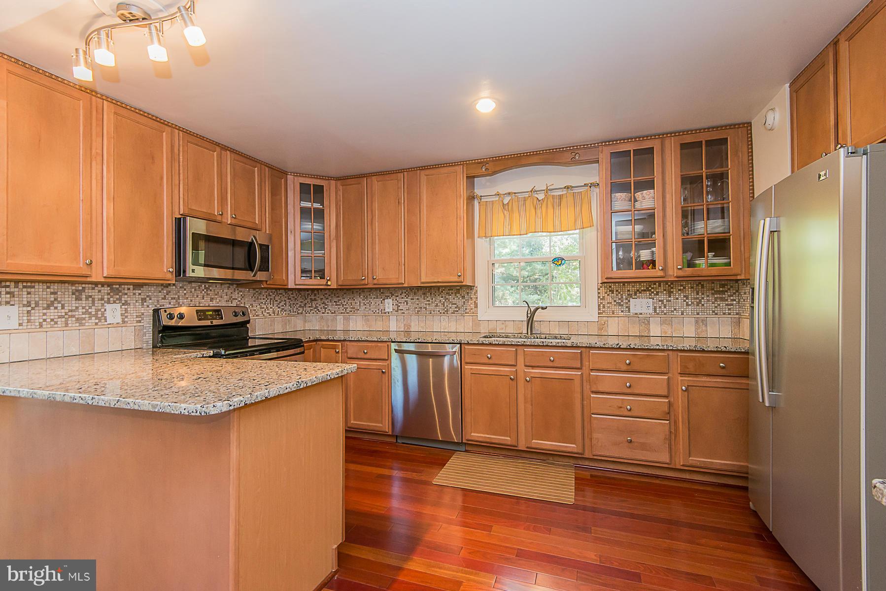 4050 Macalpine Road Ellicott City, MD 21042 - Photo 2 of 30 a kitchen with stainless steel appliances granite countertop refrigerator stove microwave and sink