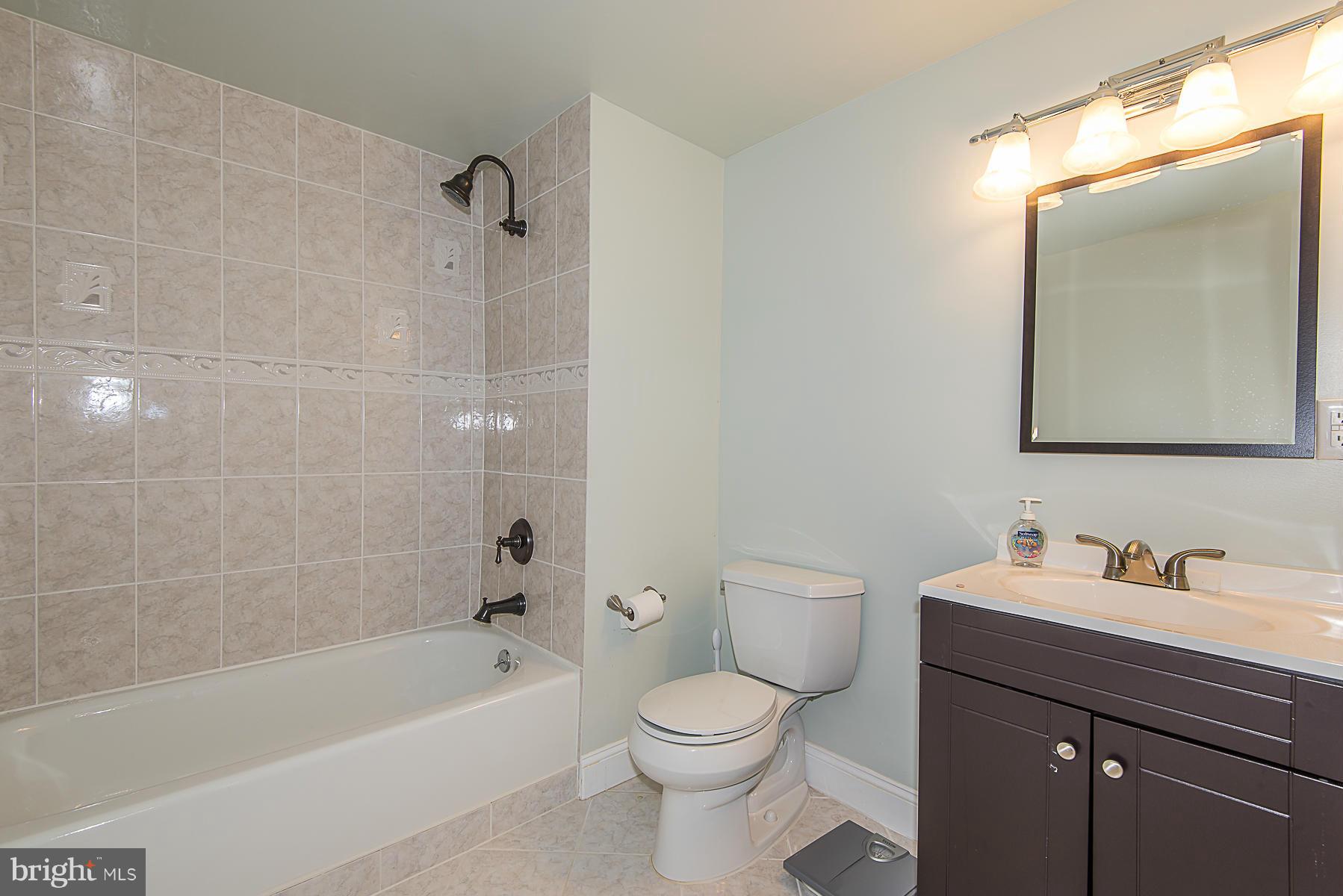 4050 Macalpine Road Ellicott City, MD 21042 - Photo 27 of 30 a bathroom with a sink a toilet a mirror a vanity and bathtub