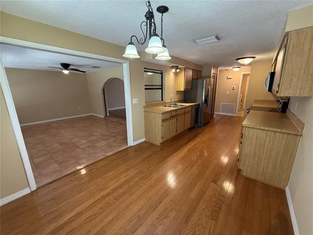 a kitchen with a sink a refrigerator and a window