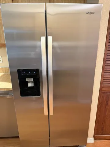 a kitchen with stainless steel appliances kitchen island wooden floors granite counter tops and a window