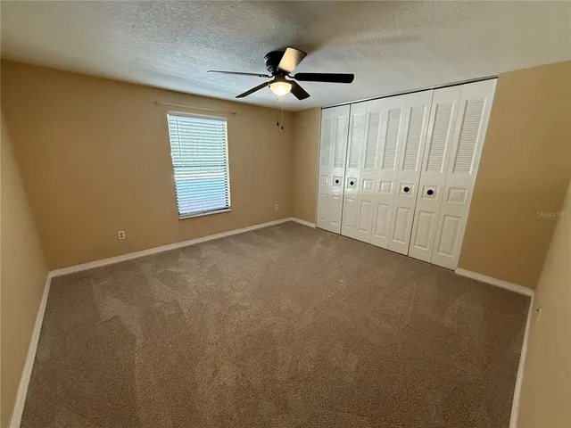 a view of an empty room with a ceiling fan