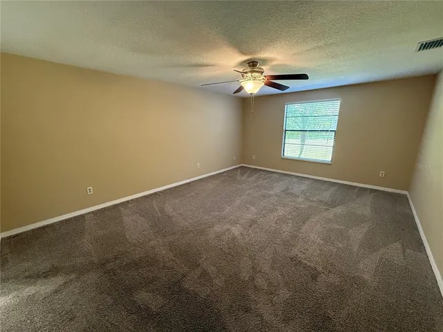 an empty room with a chandelier fan and a chandelier fan