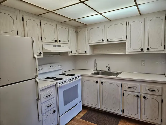 a kitchen with cabinets appliances and a sink
