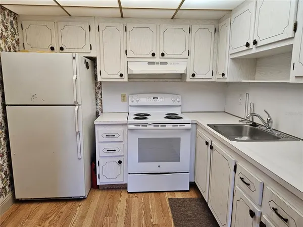a kitchen with white cabinets and white appliances