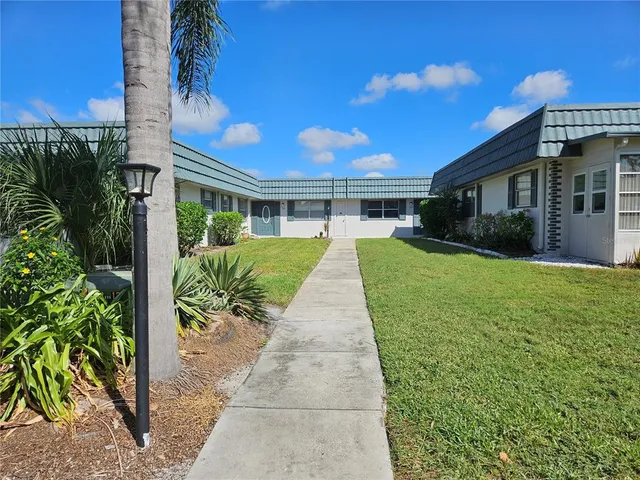 a view of a house with a yard and potted plants
