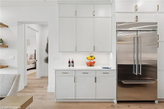 a kitchen with white cabinets and refrigerator