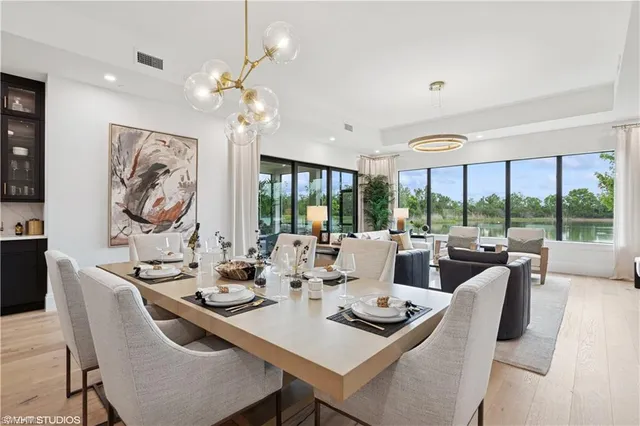 a dining room with furniture a large window and a chandelier