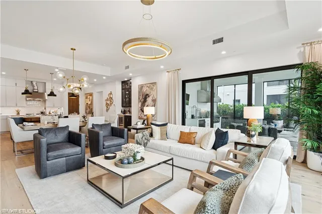 a living room with furniture kitchen view and large windows