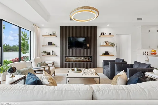 a living room with furniture a fireplace and a flat screen tv