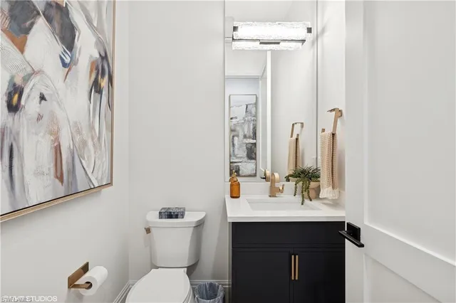 a bathroom with a sink vanity mirror and toilet