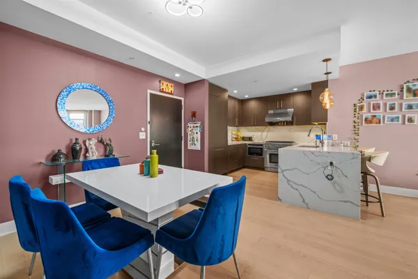a view of a kitchen with dining table and stainless steel appliances