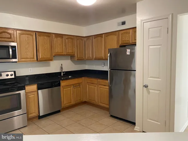 a kitchen with a refrigerator sink and cabinets
