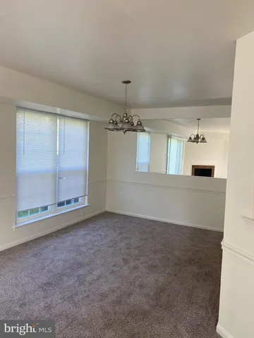 an empty room with windows and chandelier