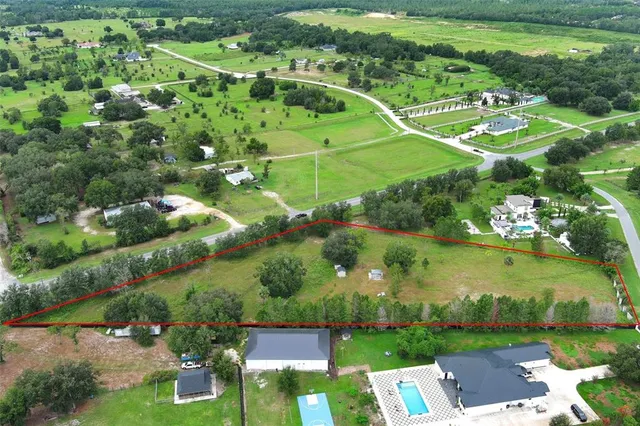 an aerial view of a residential houses with outdoor space and street view