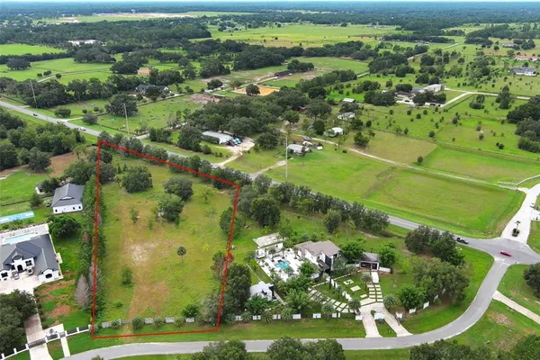 an aerial view of a residential houses with outdoor space and street view