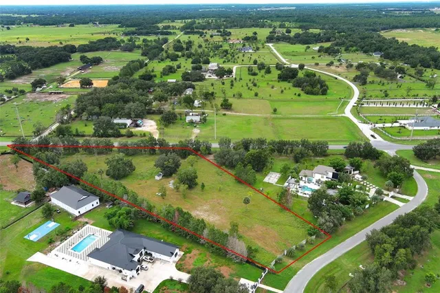 an aerial view of a residential houses with outdoor space and street view