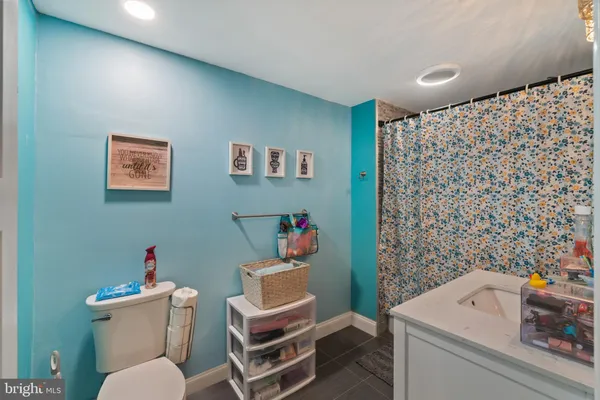 a bathroom with a granite countertop sink a toilet and a mirror