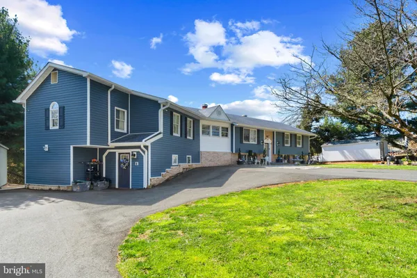 a view of a house with a yard and large tree