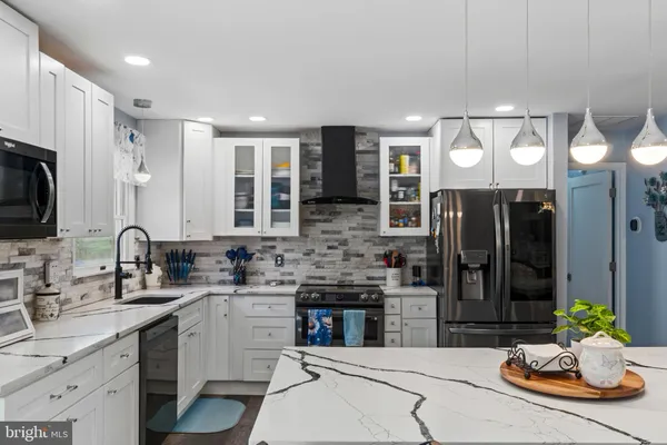 a kitchen with stainless steel appliances kitchen island granite countertop a sink and cabinets