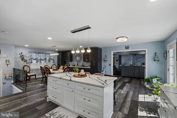 a living room with furniture kitchen view and a large window