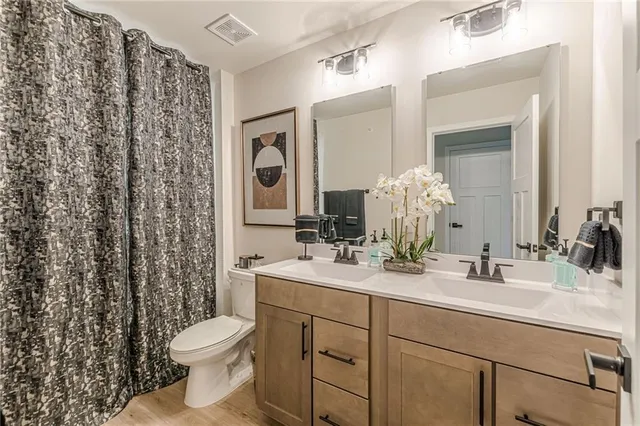 a spacious bedroom with a large bed and a chandelier