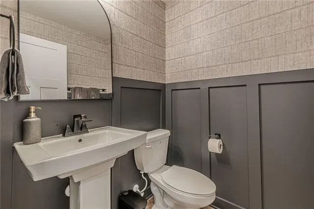 a bathroom with a sink a toilet and mirror