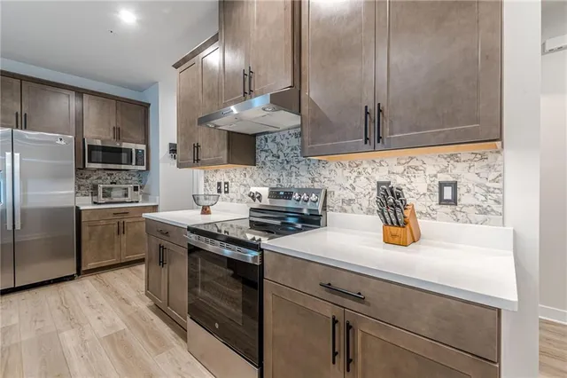 a kitchen with stainless steel appliances a sink a stove and a refrigerator