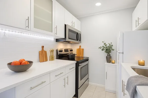 a kitchen with stainless steel appliances granite countertop a sink and a white cabinets