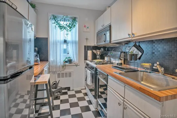 a kitchen with a sink a stove a refrigerator and cabinets