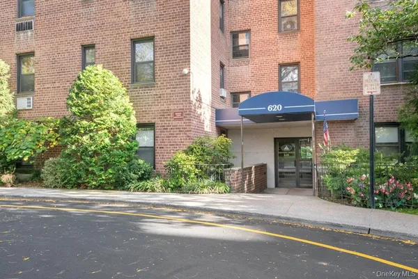 front view of a brick house with a yard