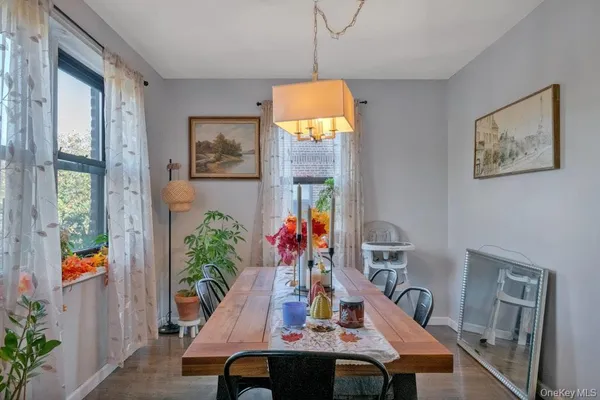 a view of a dining room with furniture one side kitchen view and wooden floor