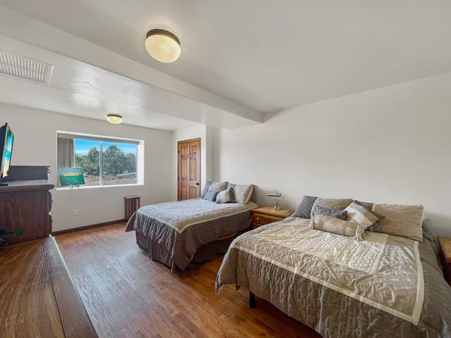 a bedroom with two beds and a large window