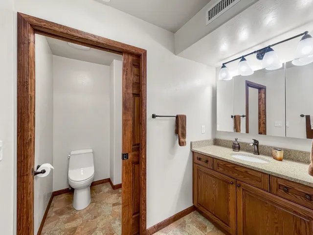 a spacious bathroom with a granite countertop sink toilet and shower