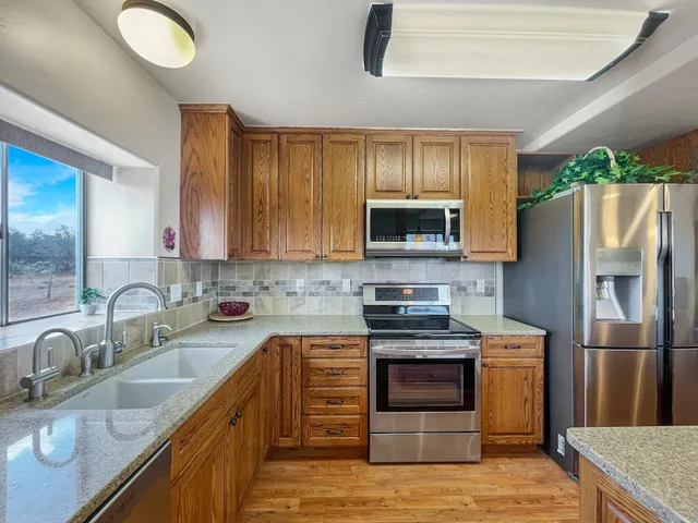 a kitchen with stainless steel appliances granite countertop a sink stove and refrigerator