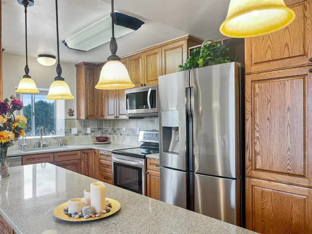 a kitchen with stainless steel appliances granite countertop a stove a refrigerator and a sink