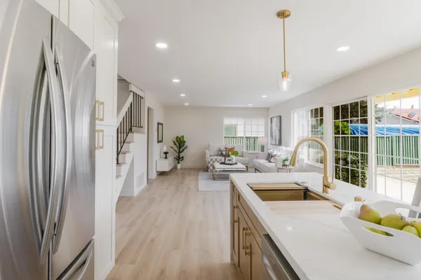 a kitchen with stainless steel appliances granite countertop a sink a stove and a refrigerator