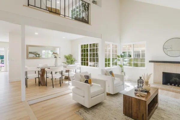 a living room with fireplace furniture and a large window