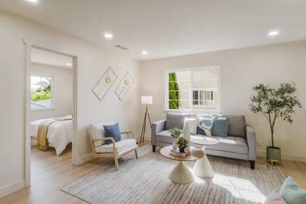 a bedroom with a bed a lamp and a large window